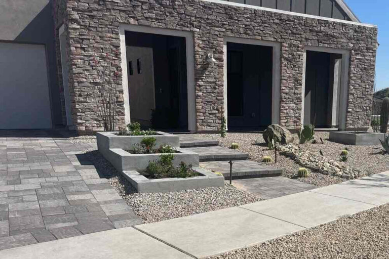 Modern desert-style front yard with paver walkway, gravel landscaping, and built-in planter beds in Phoenix.