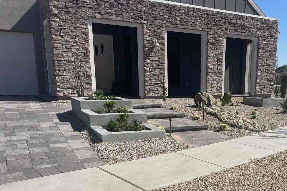 Modern desert-style front yard with paver walkway, gravel landscaping, and built-in planter beds in Phoenix.