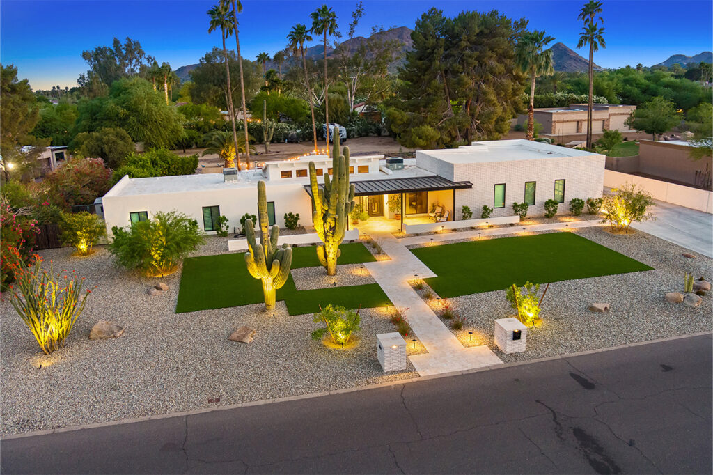 Front yard landscaping upgrades, including turf, desert plants, rocks, and modern sleek paver design with ambiance ground lighting.
